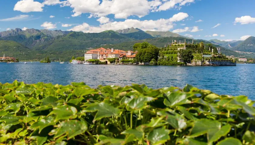 Vue d'une île avec un palais et des jardins luxuriants sur un lac, avec des montagnes en arrière-plan, dans le Piémont, Italie.