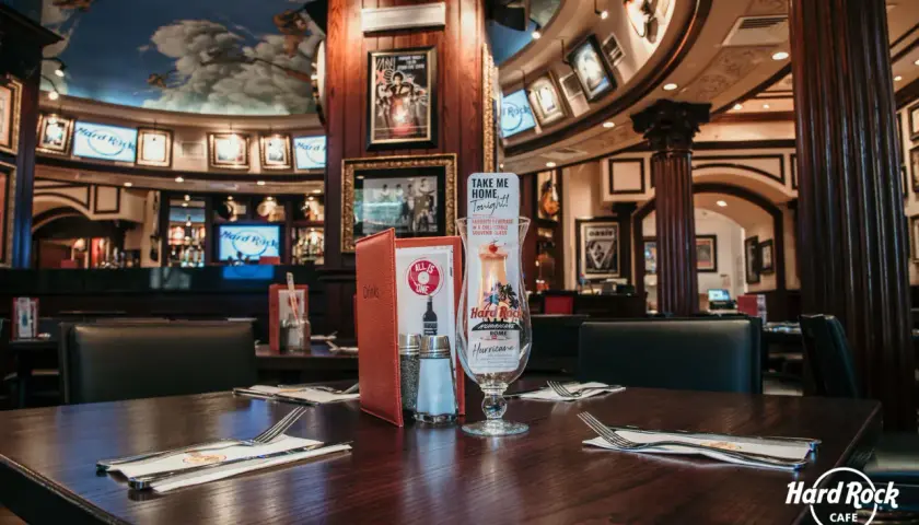 Table dressée au Hard Rock Café Rome, avec un verre souvenir "Hurricane" et des menus. Le plafond est orné d'anges.