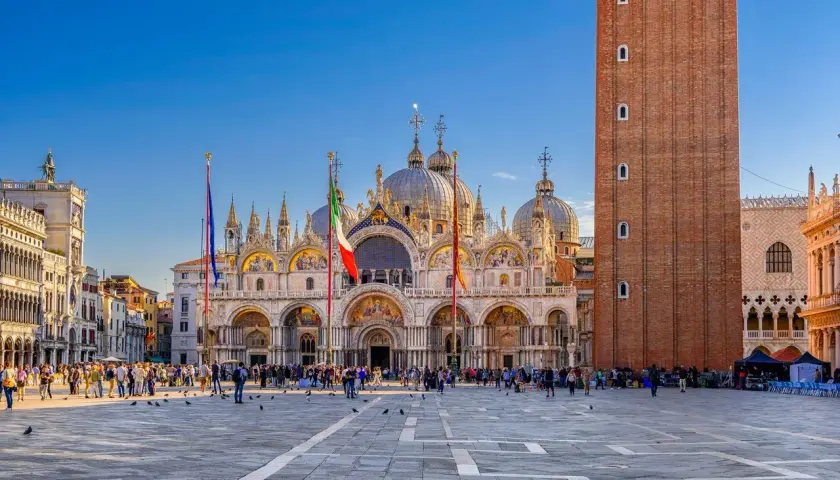 La place Saint-Marc à Venise, idéale pour visiter Venise en 3 jours. La basilique et le campanile se dressent sous un ciel bleu.
