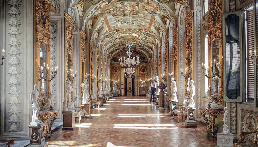 Le **Palazzo Doria Pamphilj**, un corridor orné de statues et de fresques, baigné de lumière.