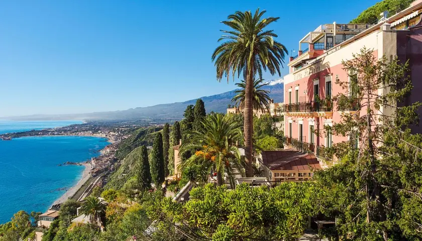 Vue panoramique d'un hôtel en Italie du Sud, bord de mer, avec des palmiers et une vue sur la côte.