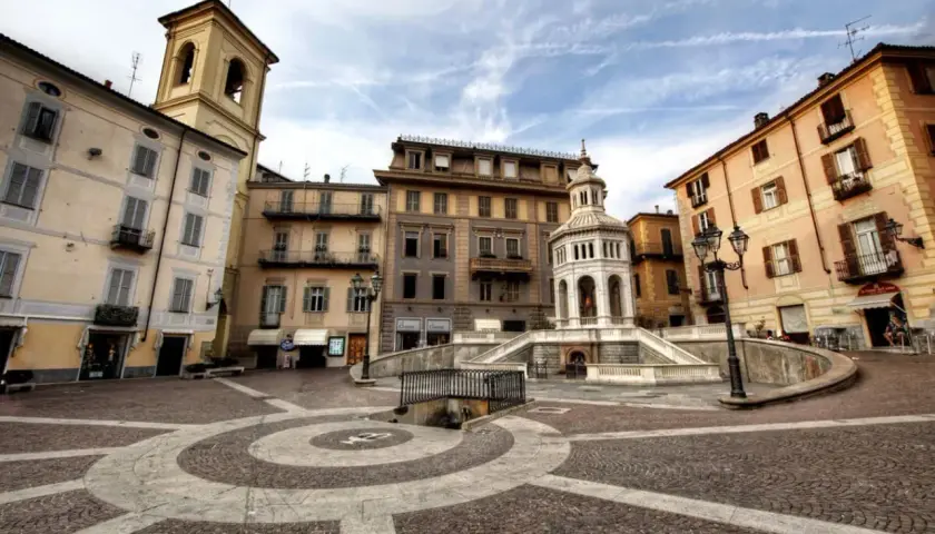 Place de la ville avec une fontaine monumentale et des bâtiments colorés. Un endroit idéal pour se détendre et acqui terme.