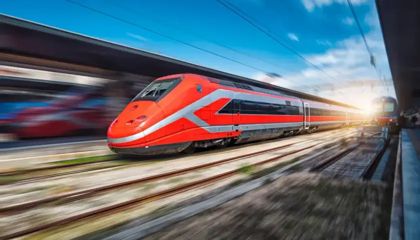 Un train rouge vif file sur les rails, prêt à emmener ses passagers de Rome à Florence.