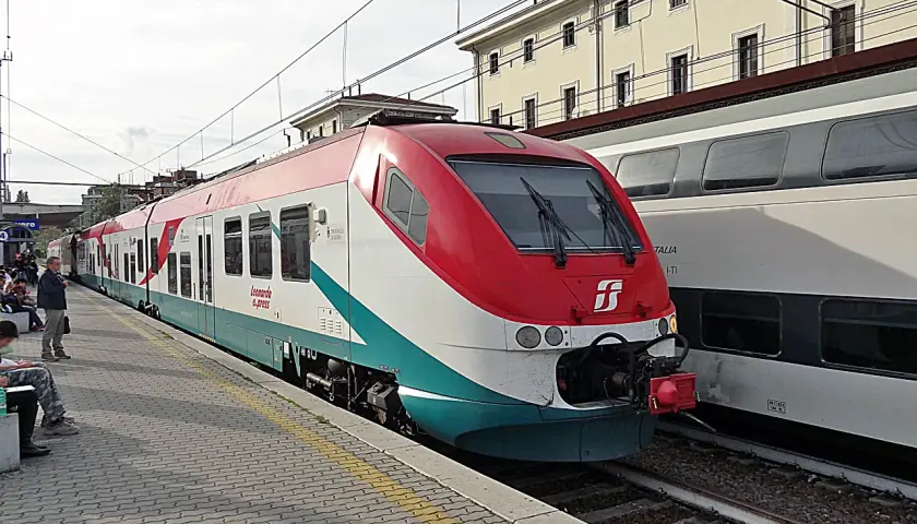 Le train Leonardo Express, reliant Fiumicino à Termini, est à quai. Des voyageurs attendent sur le quai pavé.