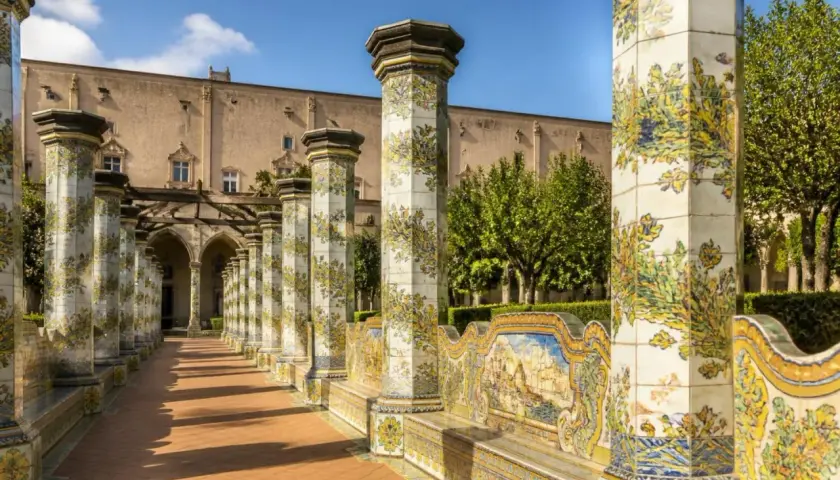 Cloître de Santa Chiara à Naples, avec ses colonnes ornées de majoliques et son banc en céramique.