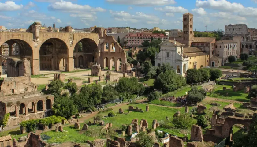 Vue panoramique du Forum Romain, idéal pour un séjour à Rome en 2 jours. Ruines antiques, églises et le Colisée en arrière-plan.