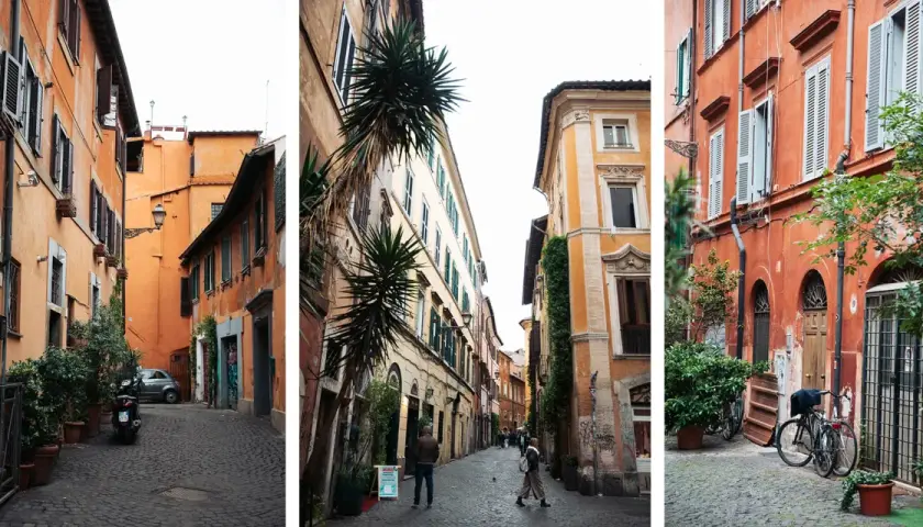 Ruelles étroites et pavées de la ville de Rome, bordées de bâtiments aux façades colorées et ornées de plantes vertes.