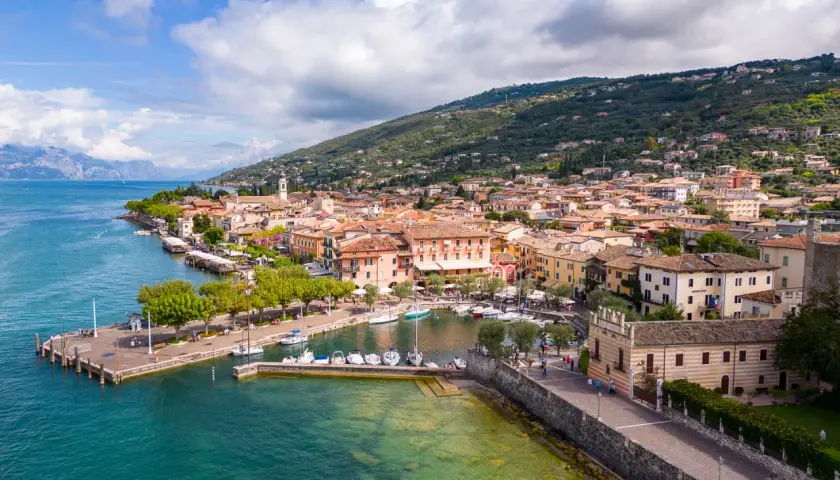 Vue aérienne de Torri del Benaco, un charmant village italien au bord du lac de Garde, avec ses maisons colorées, son port animé et ses collines verdoyantes.