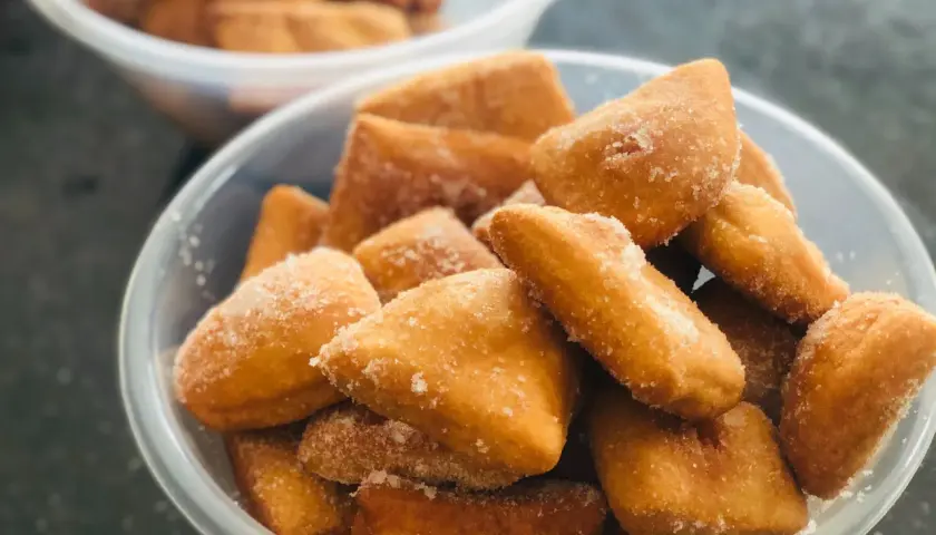 Des beignets dorés, saupoudrés de sucre, évoquent les spécialités de Venise. Un délice croustillant à savourer.