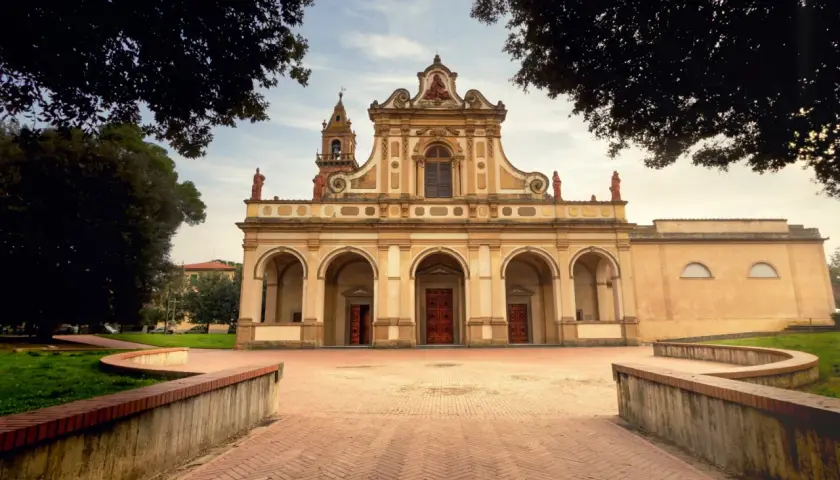 Magnifique église à Castelfiorentino, avec une façade ornée d'arches et de statues, sous un ciel doux.