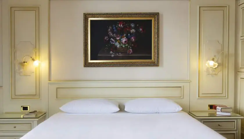 Chambre élégante d'un hôtel à Ghiffa sur le Lac Majeur, avec un tableau de fleurs au-dessus du lit.