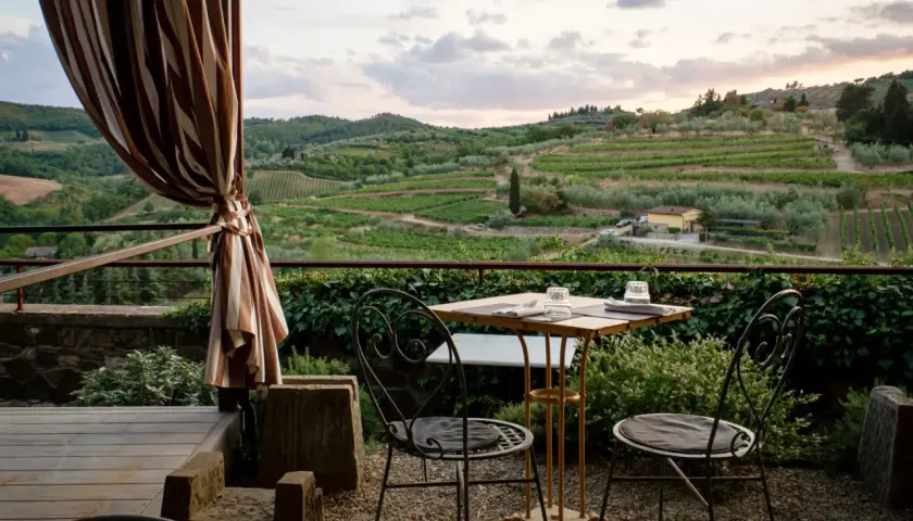 Terrasse d'agroturismo en Sicile avec vue sur les vignobles et les oliviers. Table dressée pour deux, prête pour un dîner paisible.