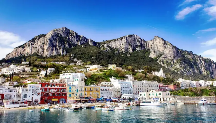 Vue du port de Capri, avec ses maisons colorées et ses montagnes escarpées. Un rêve d'évasion, loin de Rome.