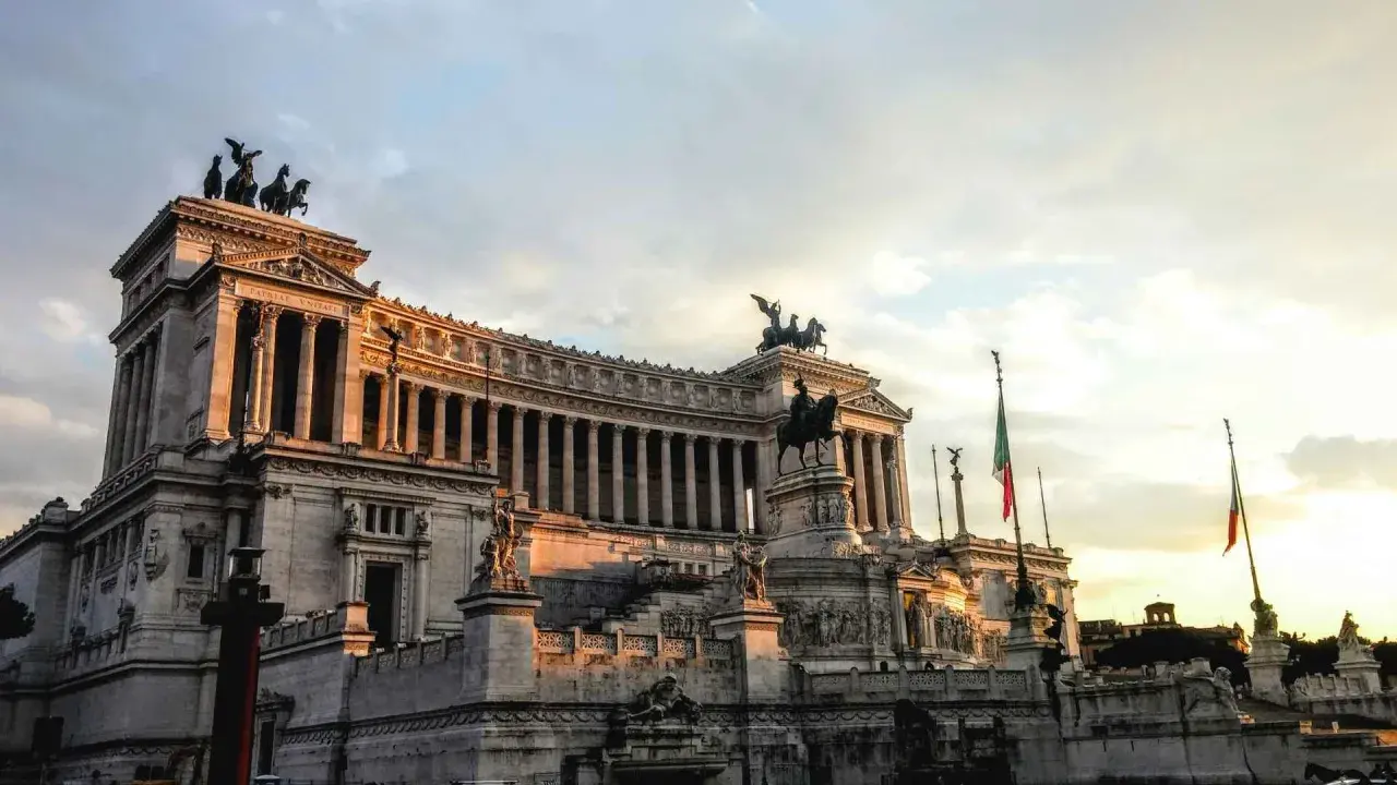 Monument imposant à Rome, idéal pour une visite avec un audioguide Rome gratuit. Le soleil couchant illumine la façade.