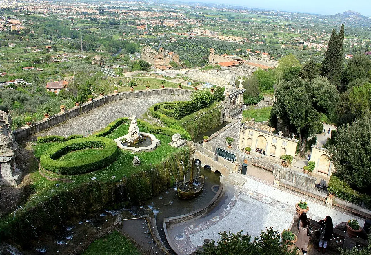 Vue panoramique de la Villa d'Este, avec ses jardins en terrasse, ses fontaines et sa statue, dominant la campagne environnante.