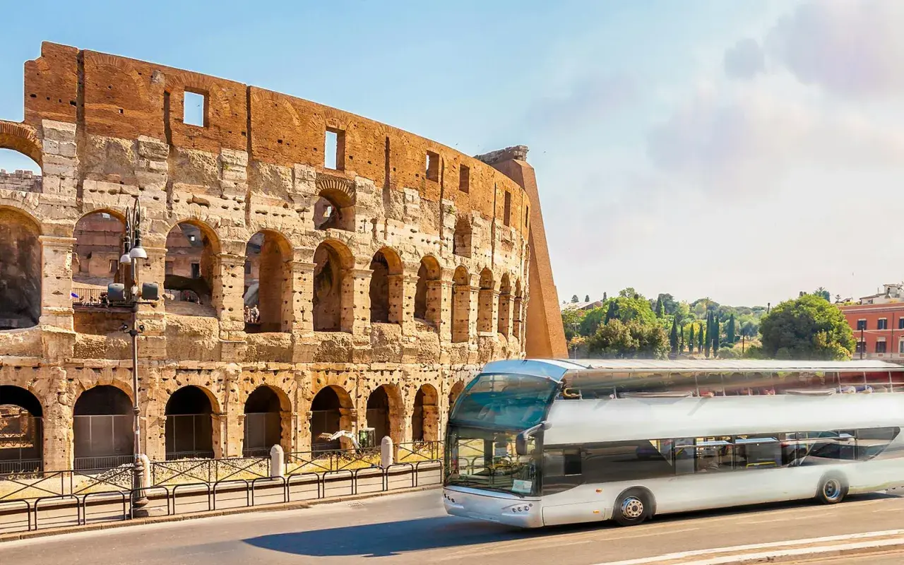 Un bus touristique passe devant le Colisée. Une carte du métro de Rome serait utile pour naviguer dans cette ville historique.