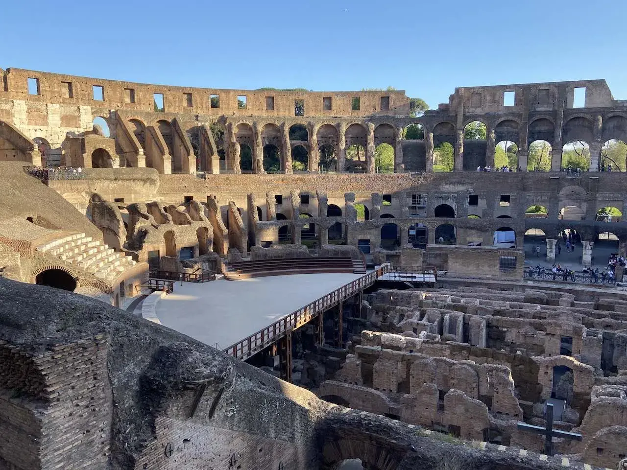 Intérieur du Colisée, vestiges de l'arène et des gradins. Un pont en bois traverse l'espace. Vérifiez l'horaire du Colisée pour votre visite.