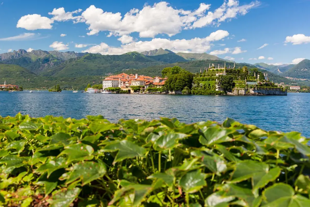 Vue d'une île avec un palais et des jardins luxuriants sur un lac, avec des montagnes en arrière-plan, dans le Piémont, Italie.