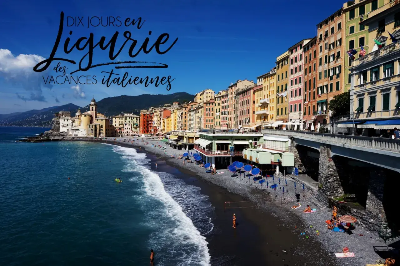 Plage de galets animée à Camogli, Ligurie, avec des maisons colorées, la mer bleue et des parasols bleus. Parfait pour des vacances en Ligurie.