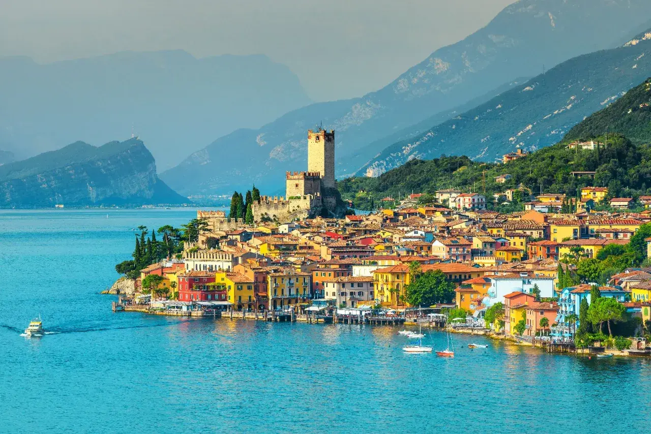 Vue pittoresque de Malcesine, un village italien coloré au bord du lac de Garde, dominé par un château médiéval.