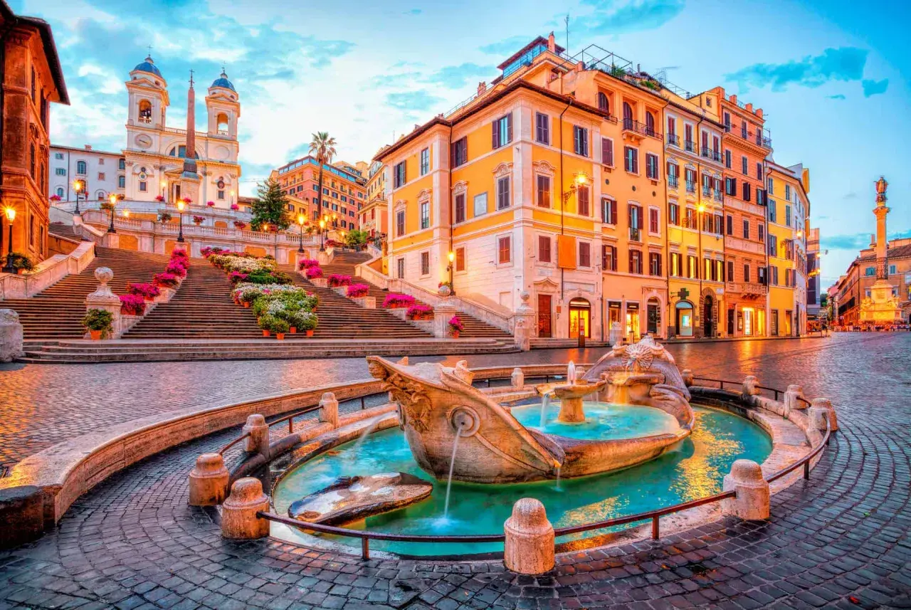 Fontaine de la Barcaccia et escalier de la Trinité-des-Monts, un tableau idyllique de Rome en mai, baigné par la lumière dorée du crépuscule.