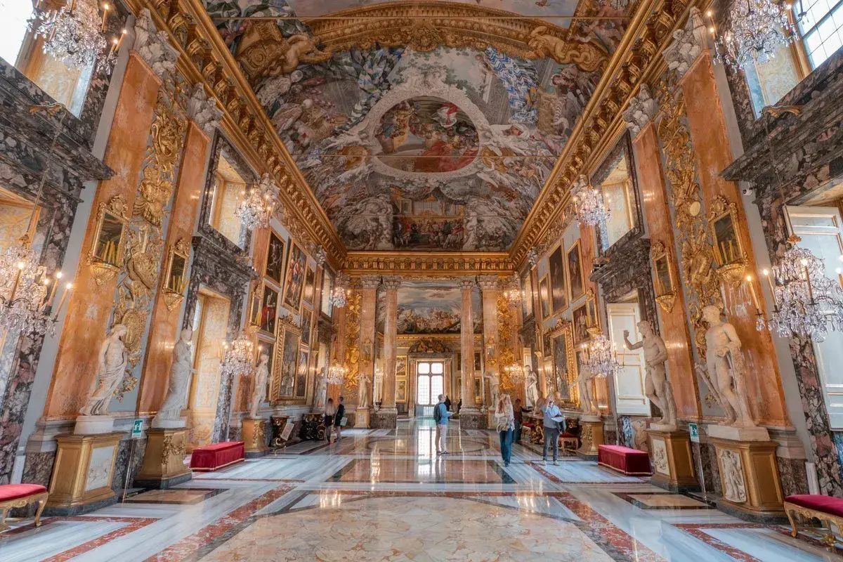 Intérieur somptueux du palais Colonna, avec fresques au plafond, statues, lustres en cristal et marbre au sol.