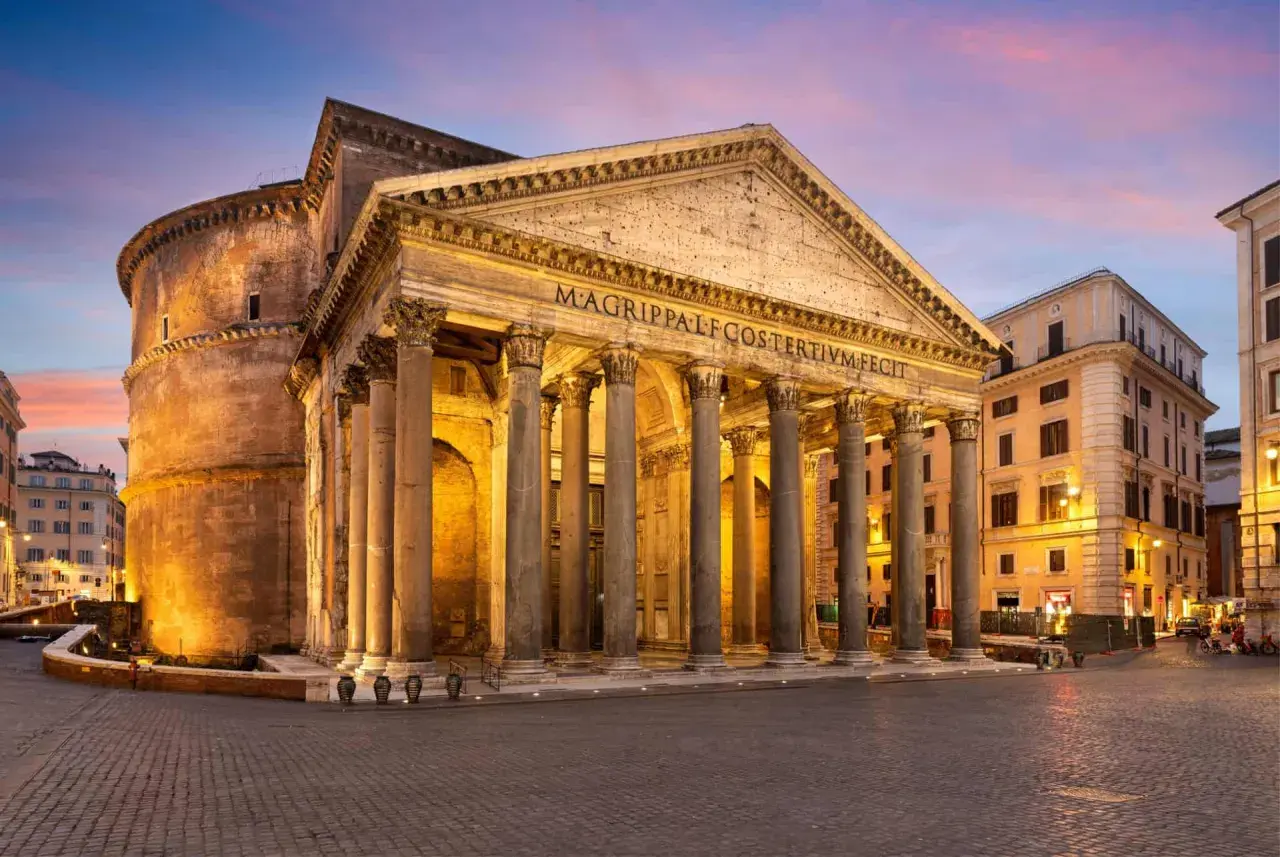 Le Panthéon de Rome, majestueux sous un ciel crépusculaire, se dresse avec ses colonnes imposantes. Un monument antique qui traverse le temps.