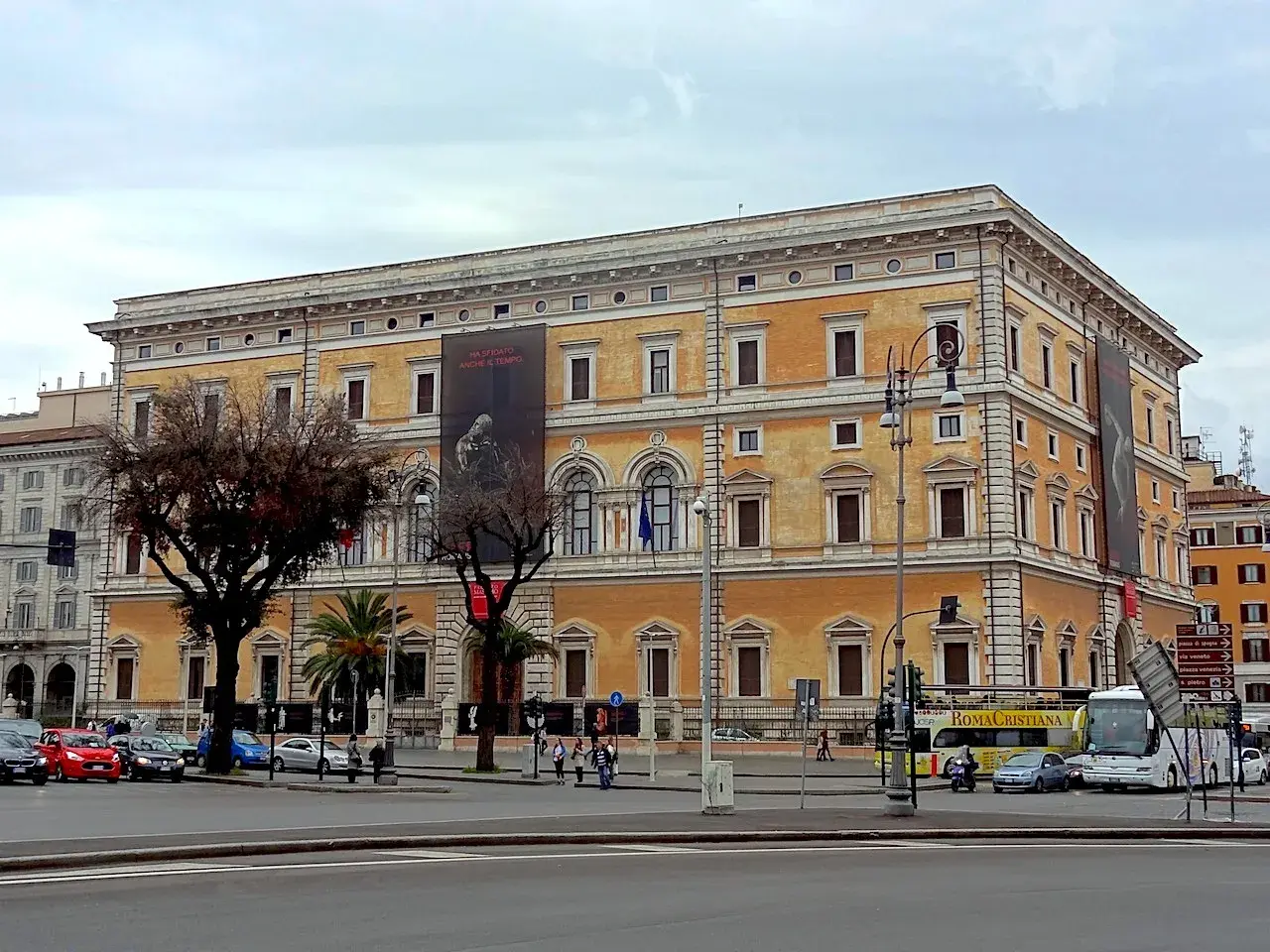 Le **Palazzo Massimo alle Terme**, un édifice majestueux, se dresse fièrement, orné d'une bannière publicitaire.