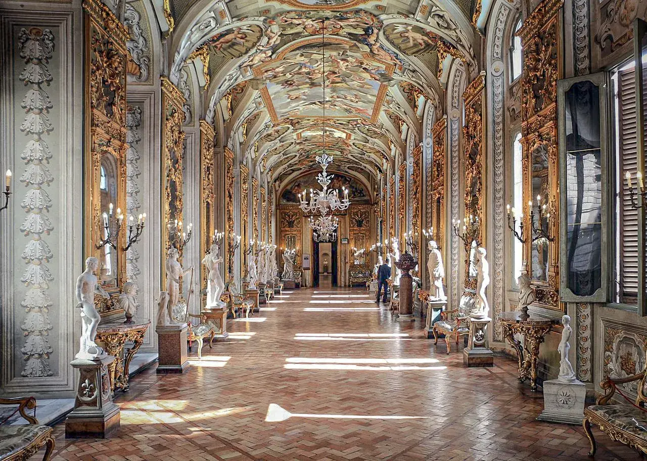 Le **Palazzo Doria Pamphilj**, un corridor orné de statues et de fresques, baigné de lumière.