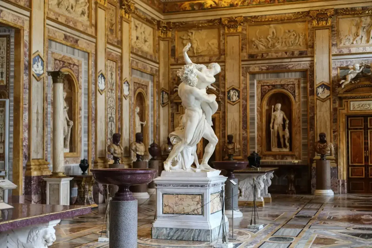 Salle somptueuse de la **Gallerie Borghese** ornée de sculptures antiques, dont le groupe du Bernin, et de riches décorations murales.