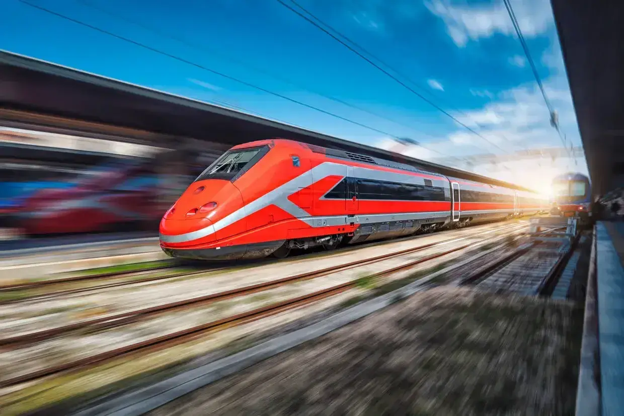 Un train rouge vif file sur les rails, prêt à emmener ses passagers de Rome à Florence.