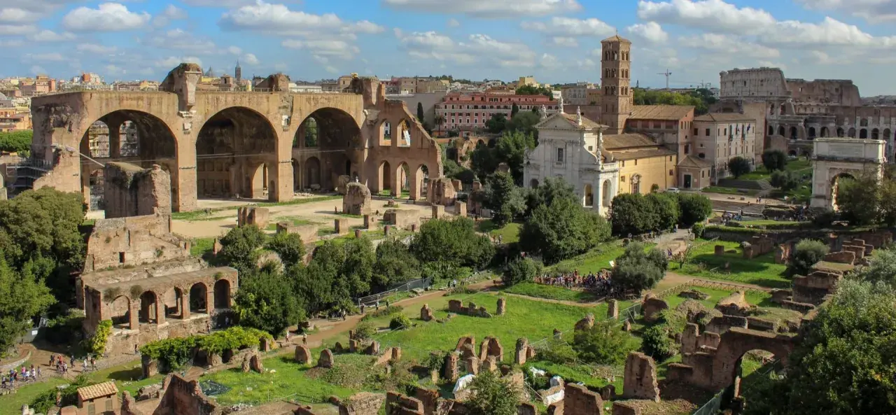 Vue panoramique du Forum Romain, idéal pour un séjour à Rome en 2 jours. Ruines antiques, églises et le Colisée en arrière-plan.