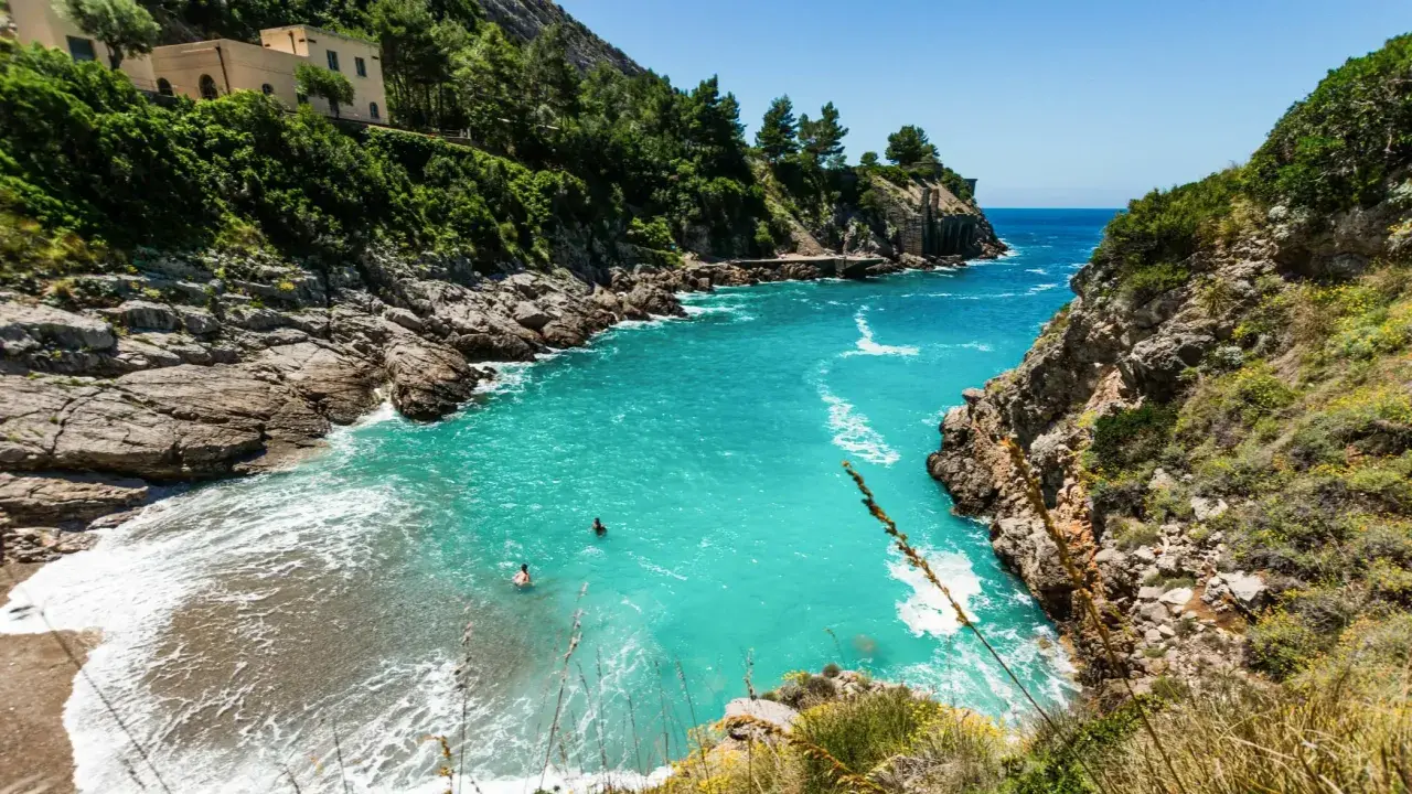 Baignade dans les eaux turquoise d'une crique isolée, un rêve de vacances sur la côte amalfitaine.