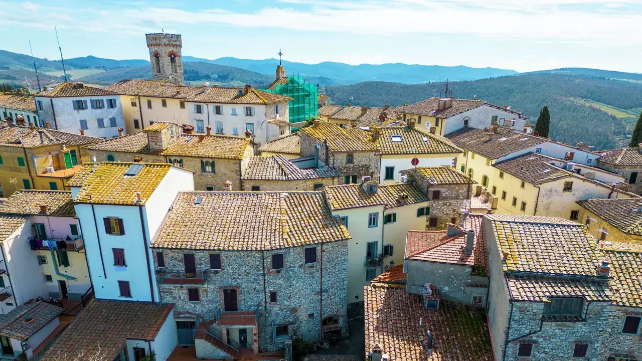 Vue aérienne d'un village toscan pittoresque, avec ses toits de tuiles ocres et ses maisons en pierre. Un paysage d'Italie authentique.