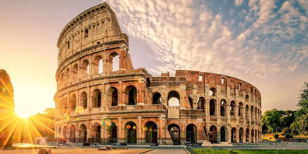 Le Colisée de Rome baigné par le soleil levant, un monument emblématique pour toute visite à Rome.