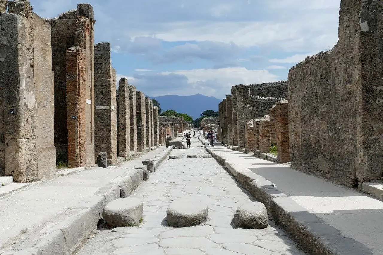 Ruines de Pompéi, une ancienne voie romaine menant vers le Vésuve. Un voyage de Rome à Pompéi est une immersion dans l'histoire.