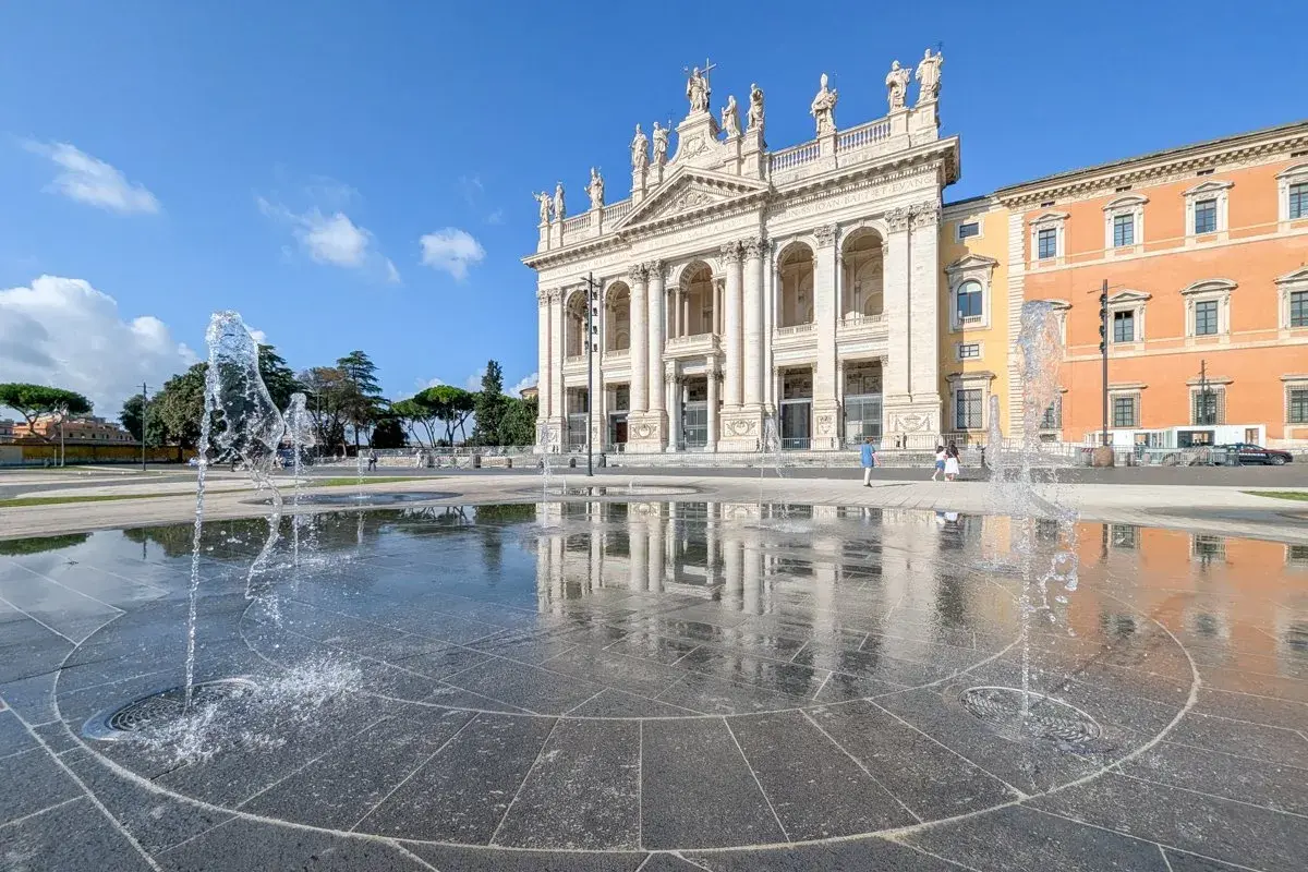 Fontaines devant la basilique Saint-Jean-de-Latran à Rome, sous un ciel bleu éclatant.