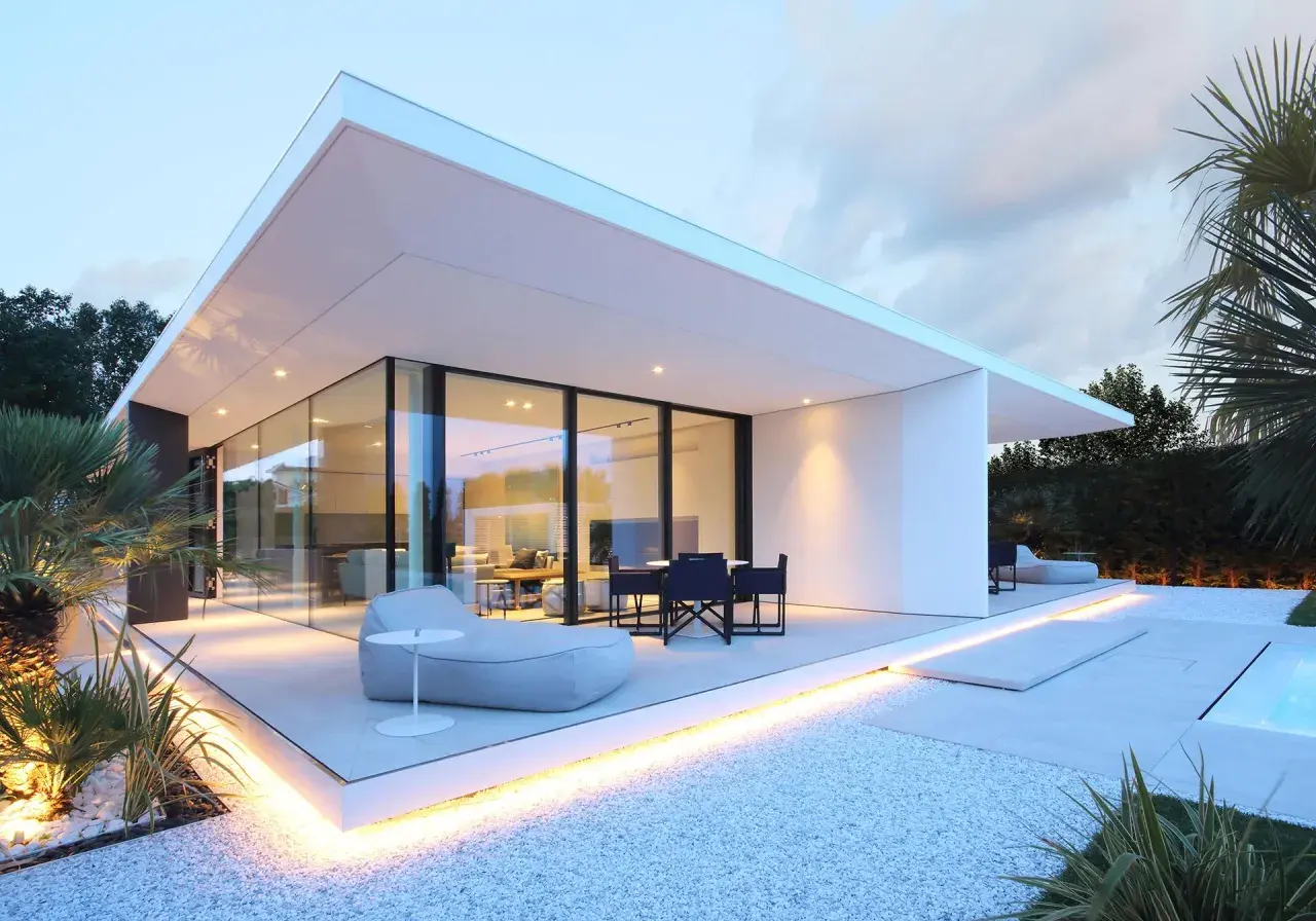 Villa moderne à Jesolo avec grandes baies vitrées, terrasse illuminée et mobilier extérieur invitant.