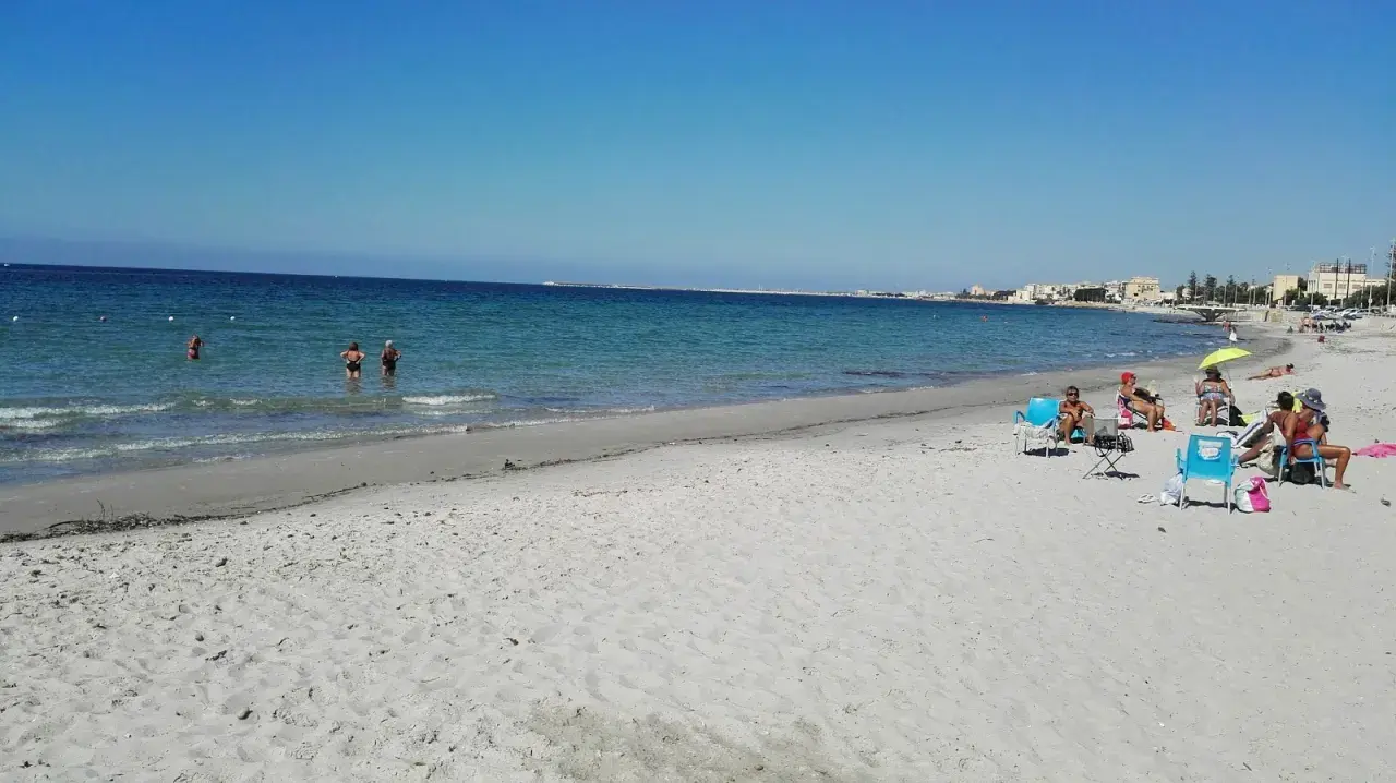 Plage de Mazara del Vallo, Italie. Des baigneurs profitent de la mer calme et du soleil sur le sable fin.