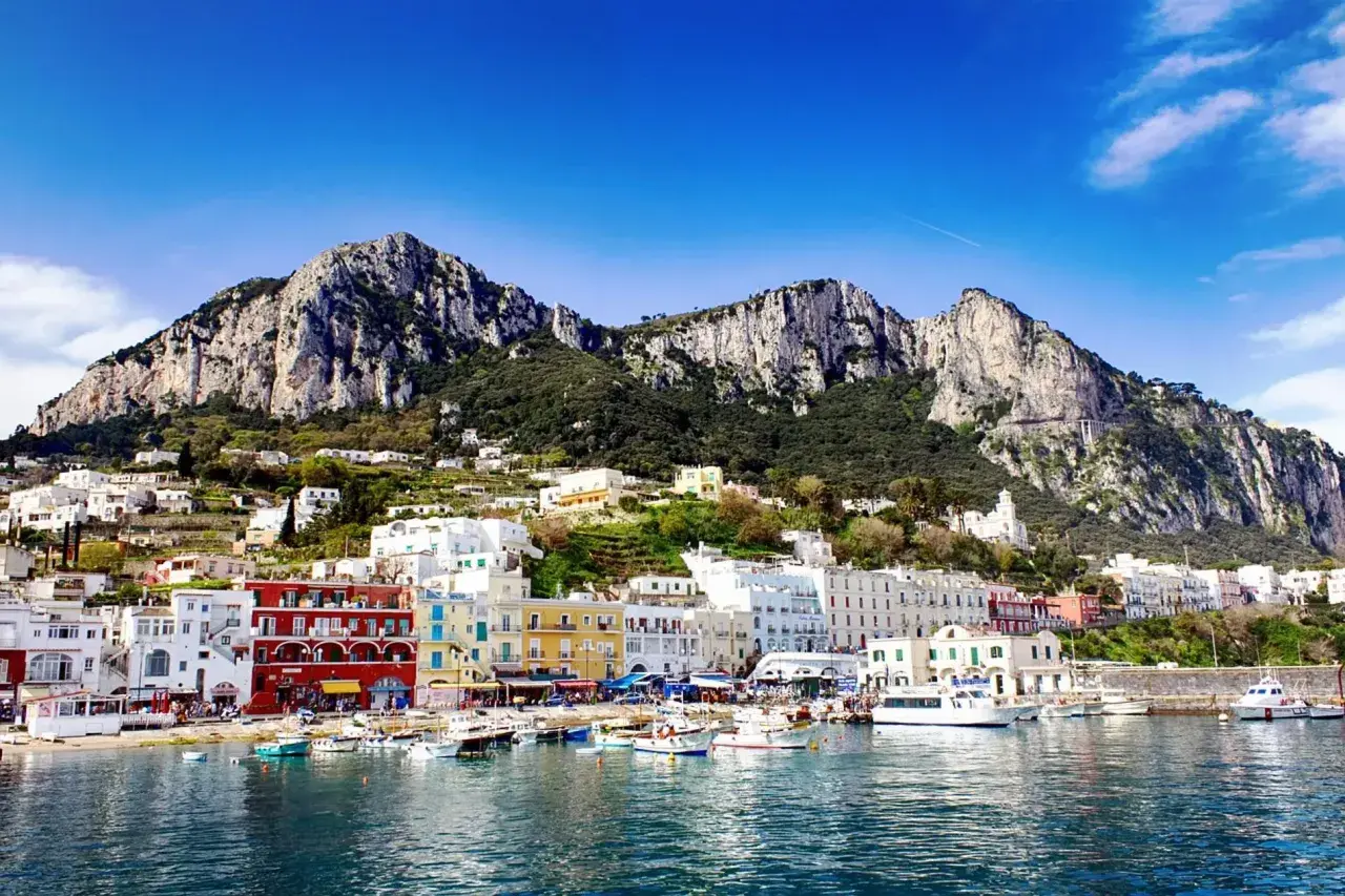 Vue du port de Capri, avec ses maisons colorées et ses montagnes escarpées. Un rêve d'évasion, loin de Rome.