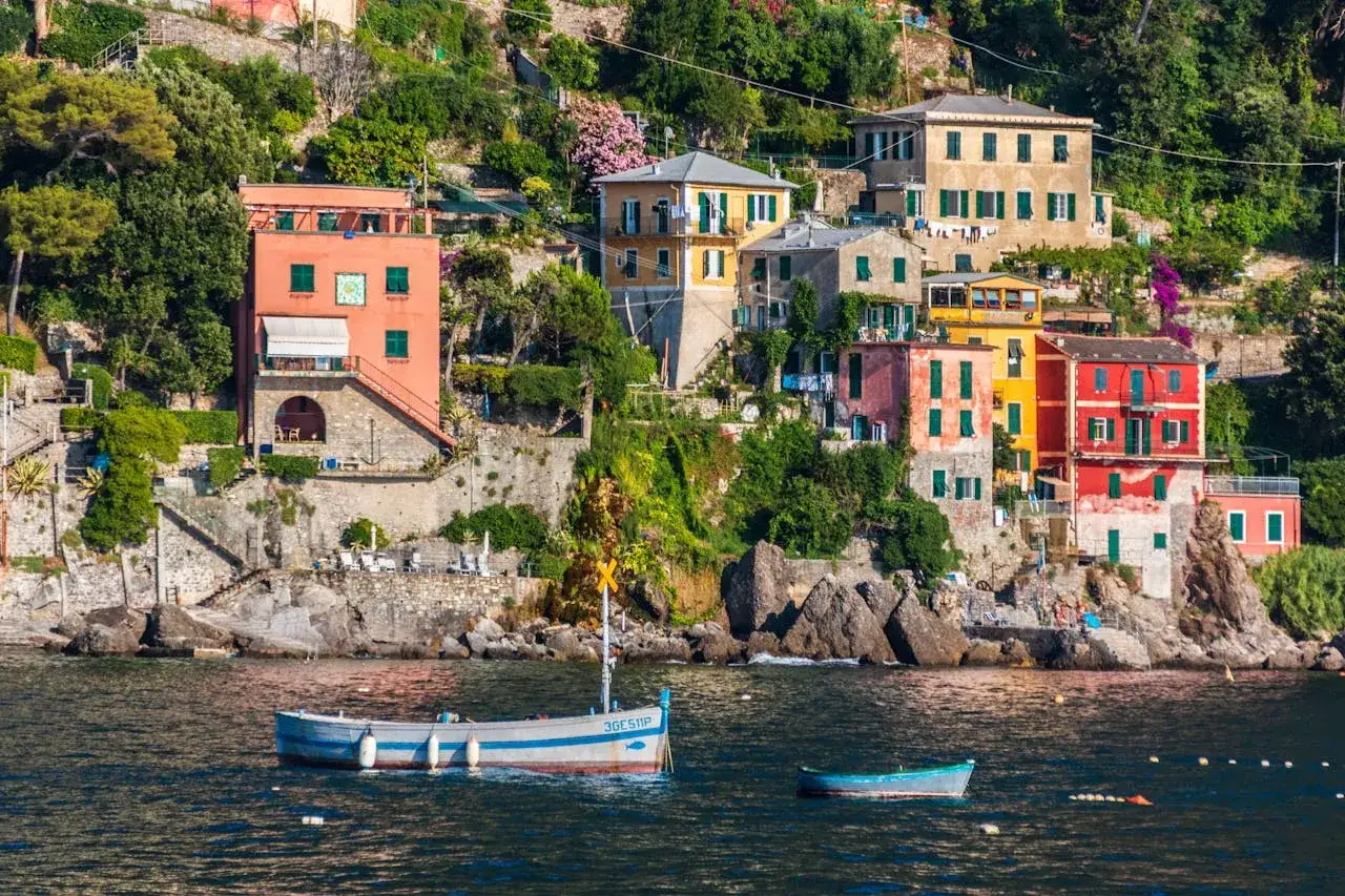 Vue pittoresque de maisons colorées accrochées à flanc de colline, sur fond de mer bleue. C'est là où se trouve la Riviera Italienne, un paysage de rêve.