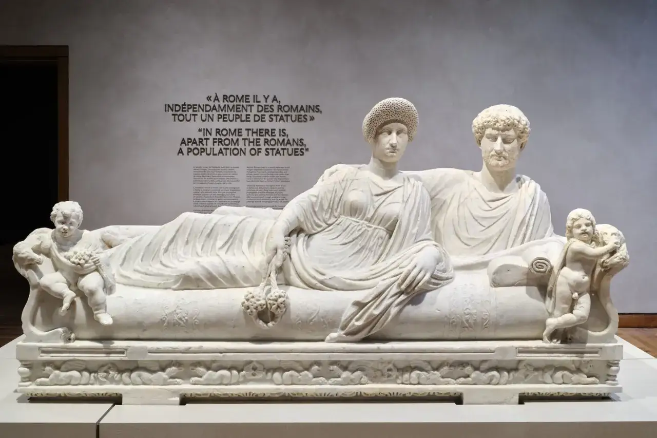 Sculpture romaine d'un couple, entouré de putti, sur un lit de repos. Une œuvre d'art qui témoigne de la grandeur de Rome.