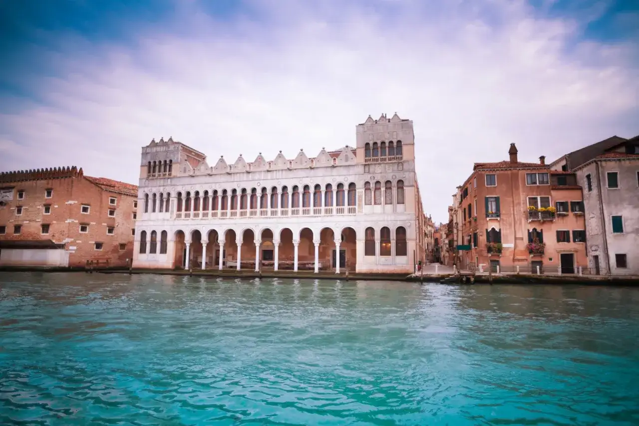 Le musée d'histoire naturelle de Venise, un palais blanc orné d'arcades, se reflète dans le canal.