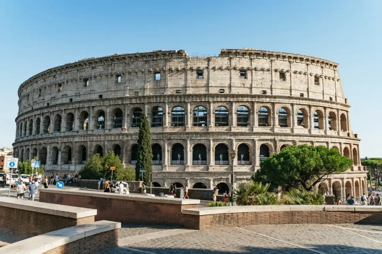 Le Colisée de Roma, un monument historique impressionnant, accueille des visiteurs sous un ciel bleu.