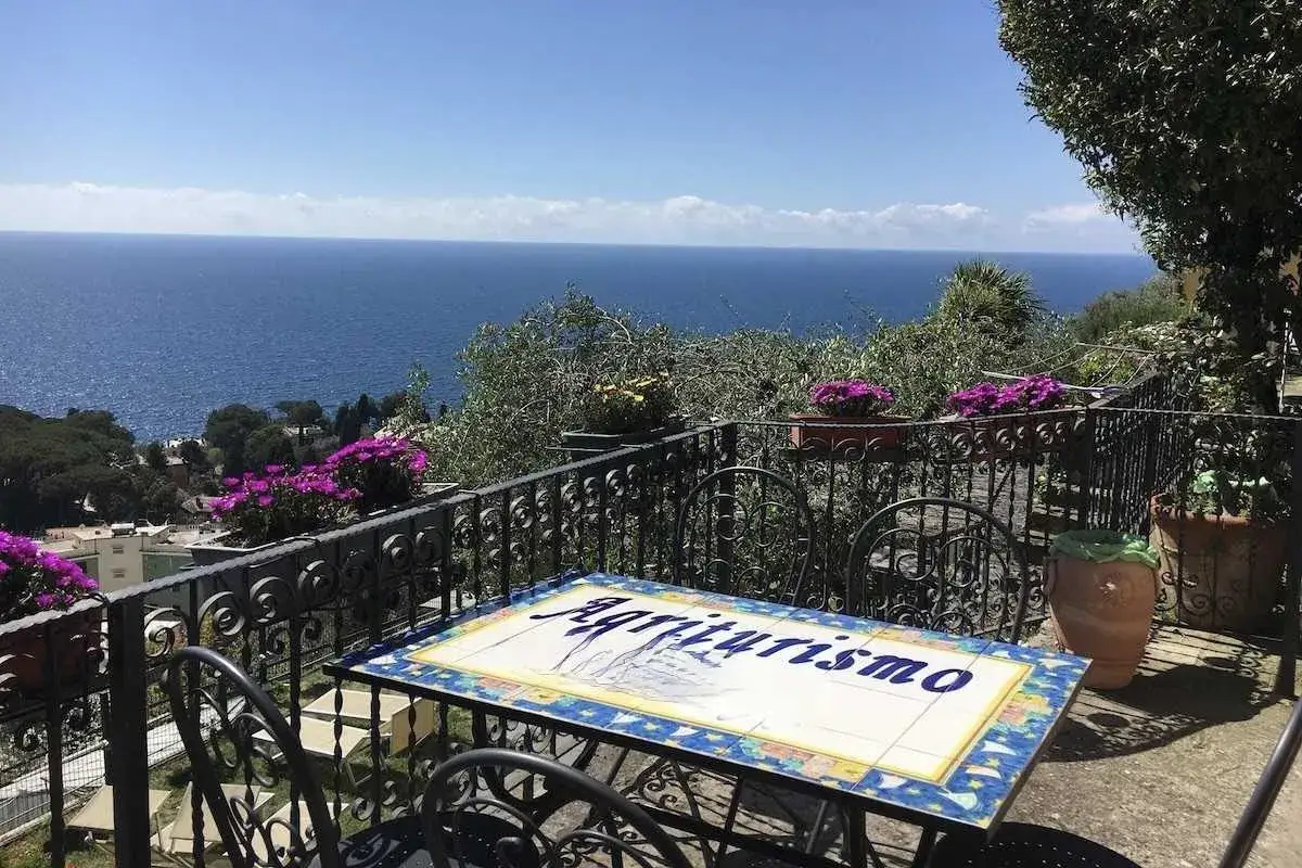 Terrasse d'un agriturismo en Ligurie, avec vue sur la mer. Table d&eacute;cor&eacute;e du mot 