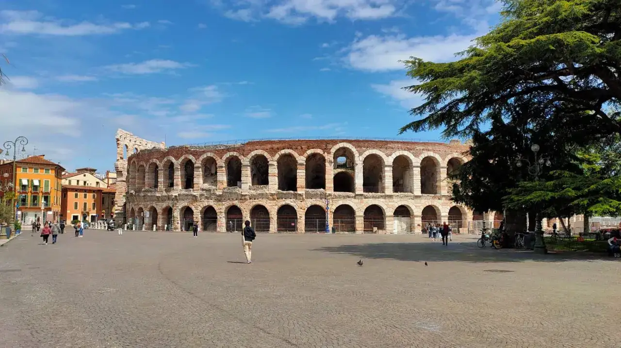 La majestueuse Arène de Vérone se dresse fièrement sous un ciel bleu, ses arches antiques invitant à un voyage dans le temps.
