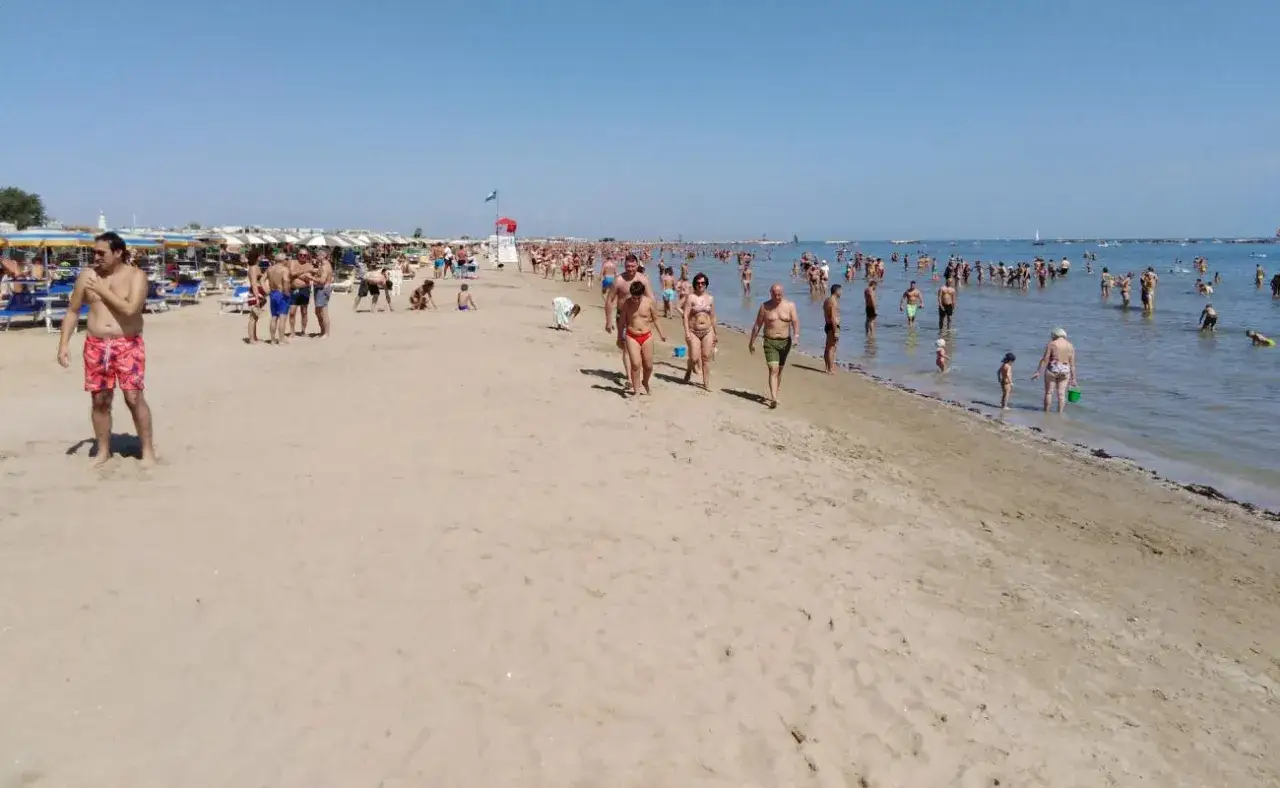 Plage animée à Cesenatico, Italie. Des baigneurs profitent du soleil et de la mer, sous un ciel bleu clair.