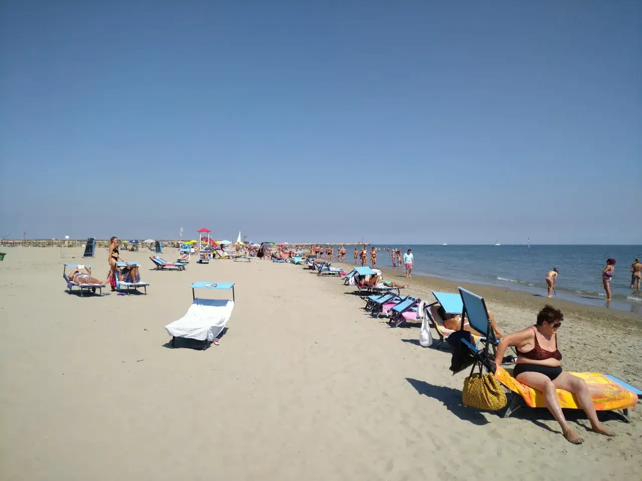 Journée ensoleillée au Lido degli Estensi, avec des baigneurs profitant du sable et de la mer.