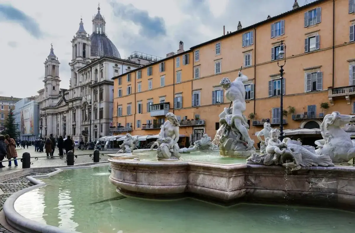 Fontaine de Neptune à Rome en mai, avec la basilique Sant'Agnese in Agone en arrière-plan.