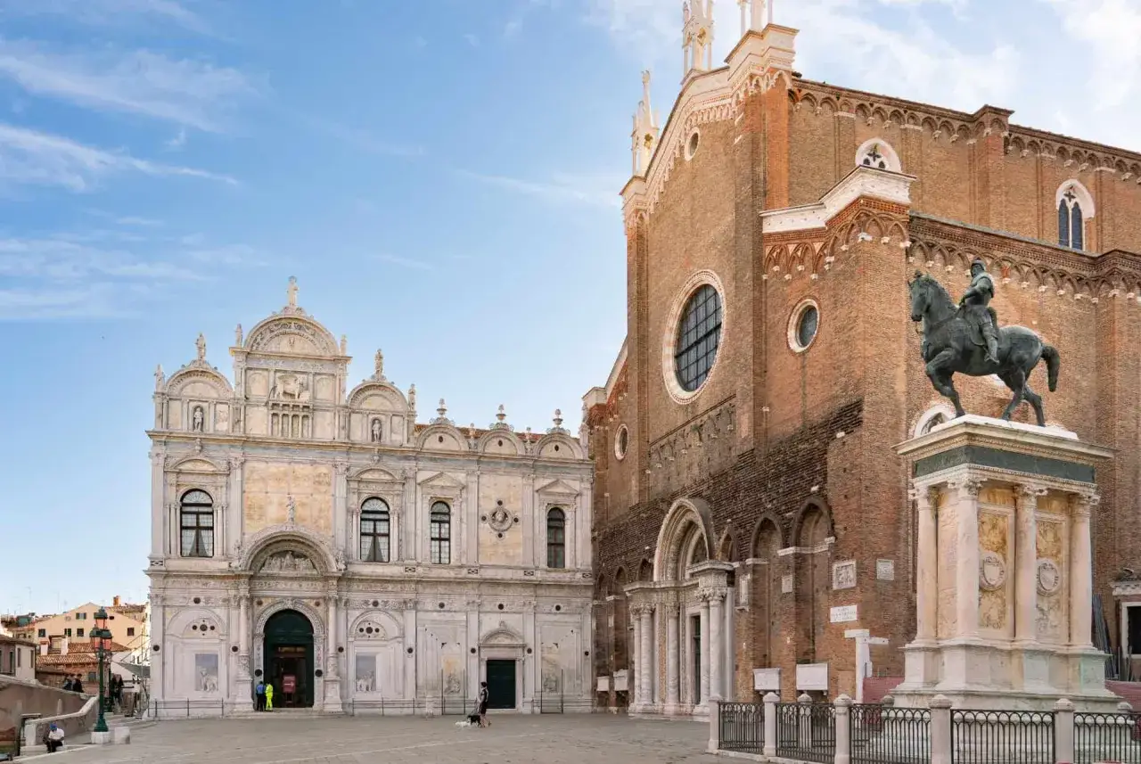 La place de San Francesco della Vigna à Venise, avec sa façade Renaissance ornée et l'imposante église en briques rouges, dominée par une statue équestre.